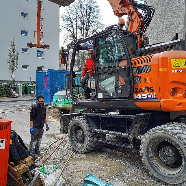 Arbeiten an den Außenanlagen des Wohnbaus: Cosmo Chiera (im Führerhaus des Baggers) und Besim Sejdija von der Firma Steidl