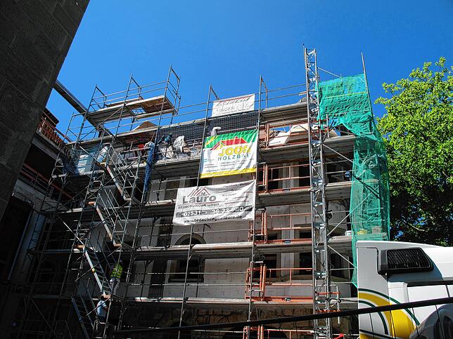 Noch ist das wieder aufgebaute Hotel Viktoria eingerüstet und das Spitzentürmchen verschwindet hinter der Baustelleneinrichtung.