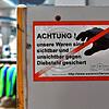Ein Aufkleber warnt mögliche Täter vor Ladendiebstahl.