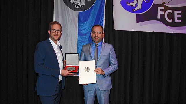 Bürgermeister Ozan Topcuogullari überreicht dem Vorsitzenden des FC Erzingen Patrick Netzhammer die Sportplakette des Bundespräsidenten.