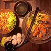 Drei Gerichte kommen im Hanoi auf den Tisch: links frittierte Hähnchenstückchen auf Sushi-Reis, rechts Reisnudeln mit vegetarischen ...