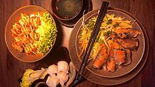 Drei Gerichte kommen im Hanoi auf den Tisch: links frittierte Hähnchenstückchen auf Sushi-Reis, rechts Reisnudeln mit vegetarischen ...