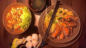 Drei Gerichte kommen im Hanoi auf den Tisch: links frittierte Hähnchenstückchen auf Sushi-Reis, rechts Reisnudeln mit vegetarischen ...