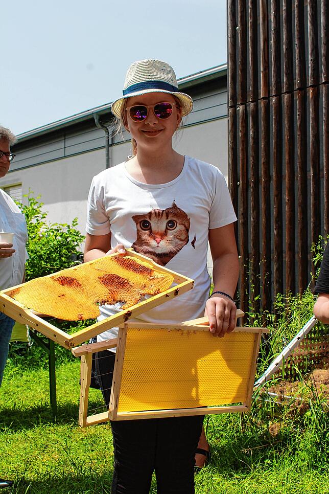 Emma Redling zeigt echte Bienenwaben (in der rechten Hand) und künstliche.