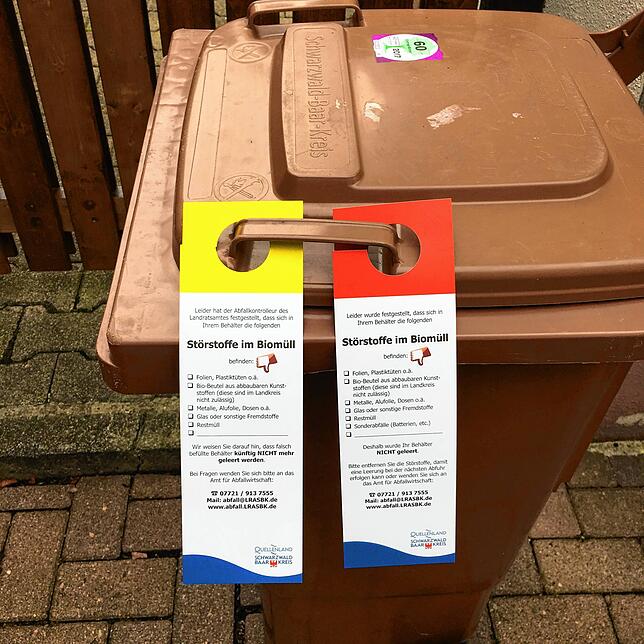 Erst die gelbe, dann die rote Karte. Biomülltonne mit zwei Warnanhängern aus dem Schwarzwald-Baar-Kreis als Beispiel dafür, was bei ...