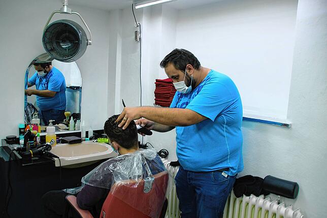 Emran Greku vom Salon Aydo mit einem Kunden.