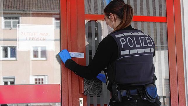 Sina Hipp von der Kriminalpolizei versiegelt nach der Spurensicherung Tür der SB-Filiale in Mühlingen, in der ein Geldautomat ...