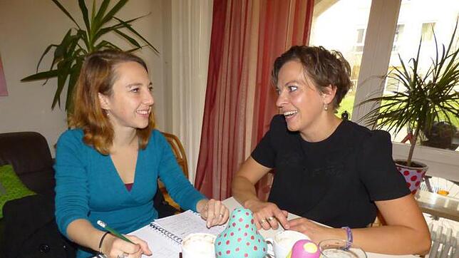 SÜDKURIER-Mitarbeiterin Nicole Burkhart (links) unterhält sich im Wohnzimmer des Mehrgenerationenhauses mit Eva Fast. Bild: Stefanie ...