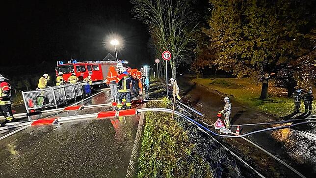 Die Feuerwehr leitet mit Pumpen und Schläuchen Regenwasser über die B33 bei Stetten.