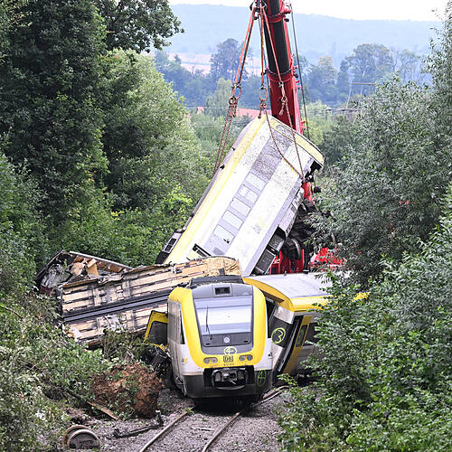 28.07.2025, Baden-Württemberg, Riedlingen: Mit einem Kran wird an der Unfallstelle an der ein Regionalzug entgleist ist ein Waggon ...