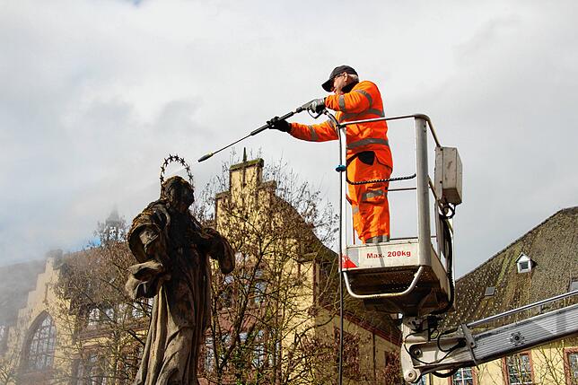 Enrico Hoffmann vom Baubetriebshof Waldshut-Tiengen befreit die Heiligenstatuen beim oberen Tor in Waldshuter von Moos und Schmutz.