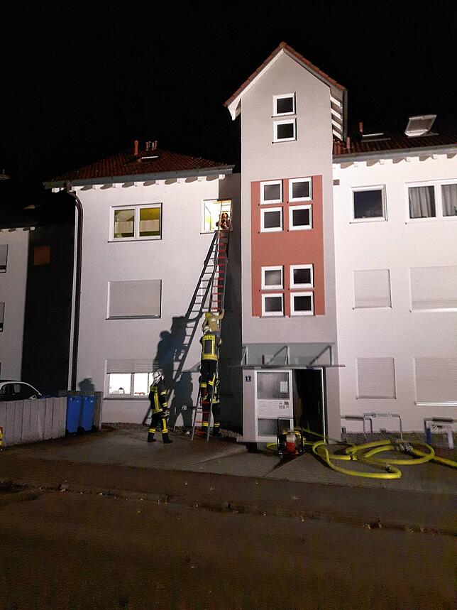 Mit der Leiter bringt die Feuerwehr die Bewohner des Hauses in Sicherheit.