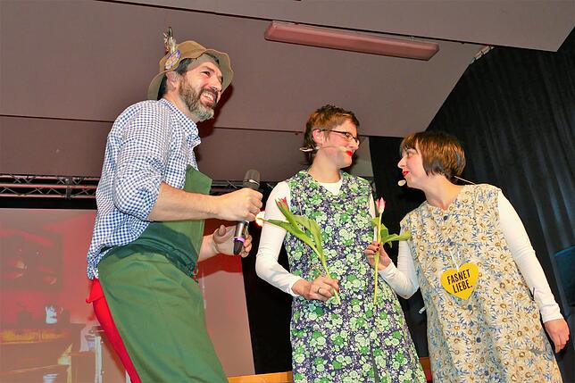 Gärtner Florian Käfer übergibt den Schwätzerinnen Corinna Schau (Mitte) und Simone Keller eine Tulpe.