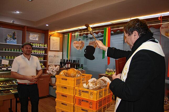 Pater Slavomir besprengt das von Bäckermeister Alexander Matt gebackene Brot mit Weihwasser.