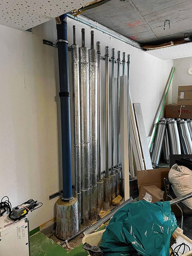 Die Heizungsrohre werden durch die Bestandsetagen in die beiden neuen Stockwerke gezogen.