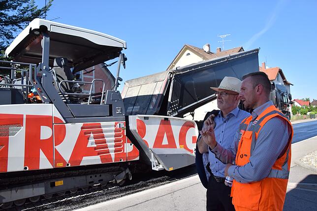 Diplom Ingenieur Martin Muschalla (rechts) erklärt Bürgermeister Rainer Stolz alles über den Clean Air-Asphalt und wie das Asphaltieren ...