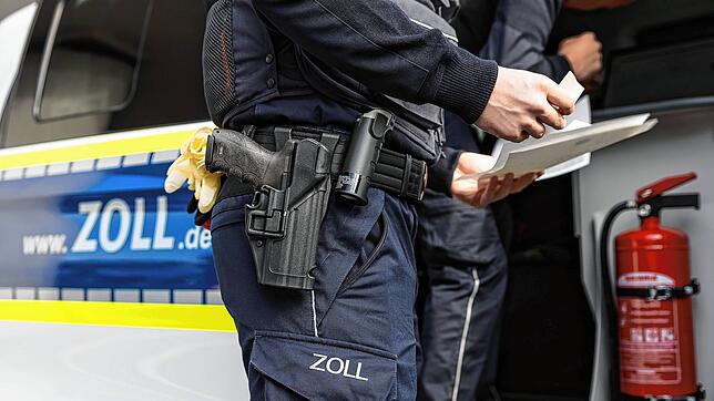 24.09.2022, Hessen, Frankfurt/Main: Zollbeamte überprüfen die Papiere Taxifahrers. Am Frankfurter Flughafen wurde eine Kontrollaktion ...
