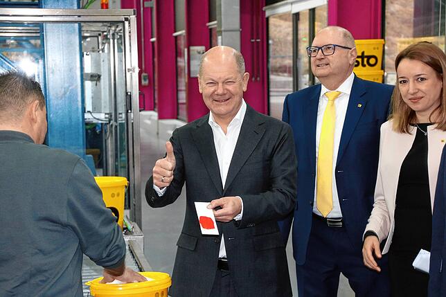 Echt rot: In der Produktionshalle durfte der Kanzler selbst den Pinsel schwingen