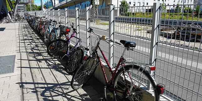 Provisorisch festgemachte Räder an Gittern und Zäunen am Bahnhof Petershausen. Dieses Bild soll bald der Vergangenheit angehören.