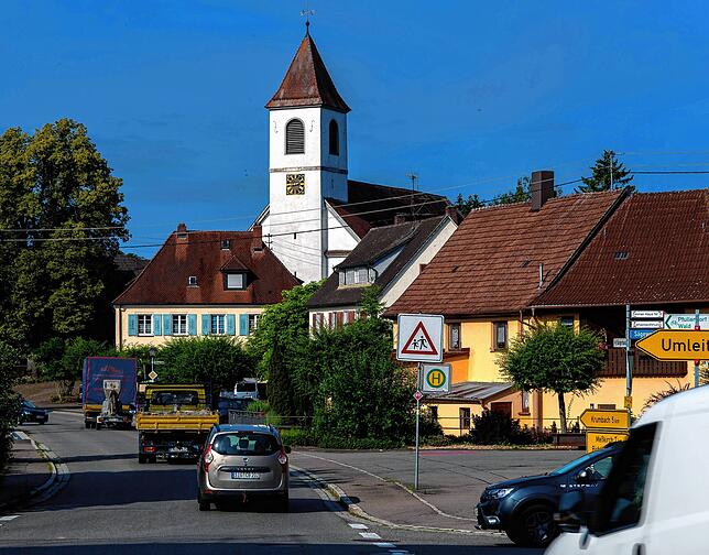 Blick in die Sauldorfer Hauptstraße. Handwerker fahren frühmorgens zu den Baustellen im Neubaugebiet.