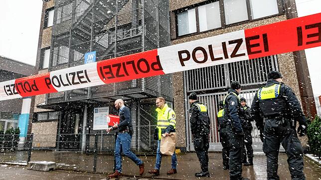 Polizisten stehen vor dem Gebäude der Zeugen Jehovas.