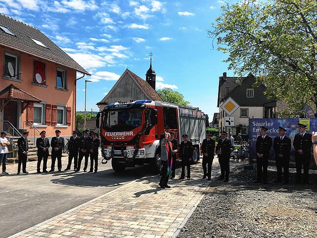 Die Fahrzeugweihe ist vorbei, nun bekommen auch die Feuerwehrkameraden noch ein paar Tropfen Weihwasser ab.