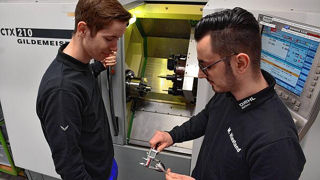 Julian Jurtz und Matthias Hiestand (von links) stehen vor der CNC-Drehmaschine, mit der Ringe und der ...
