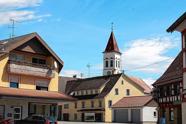 Hinter den Häusern der geschwungenen Hauptstraße lugt der Turm der St. Mauritius Kirche hervor.