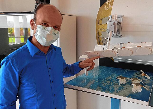 Space-Tech-Manager Kolja Nicklaus zeigt auf ein Modell der ISS. Mit an Bord ist Technik von Space Tech.