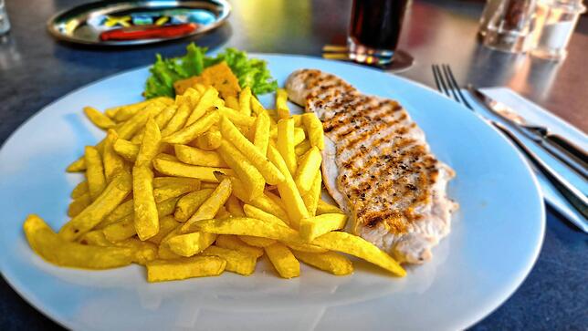 Putensteak mit Pommes – dazu gibt es Kräuterbutter sowie jeweils eine Tüte Mayo und Ketchup.