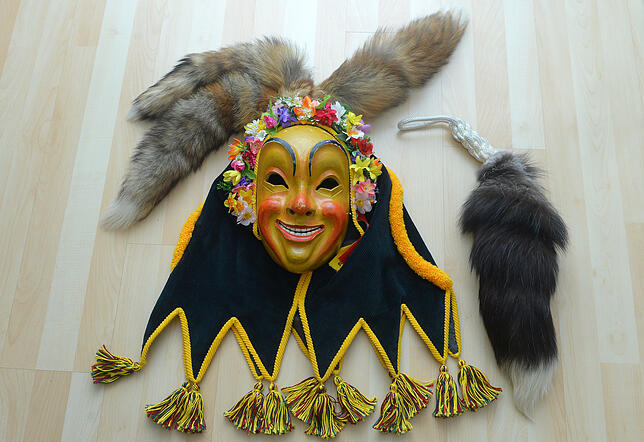 Maske, Blumenkranz und Fuchsschwänze sind obligatorische Bestandteile des Hafennarrenhäses.