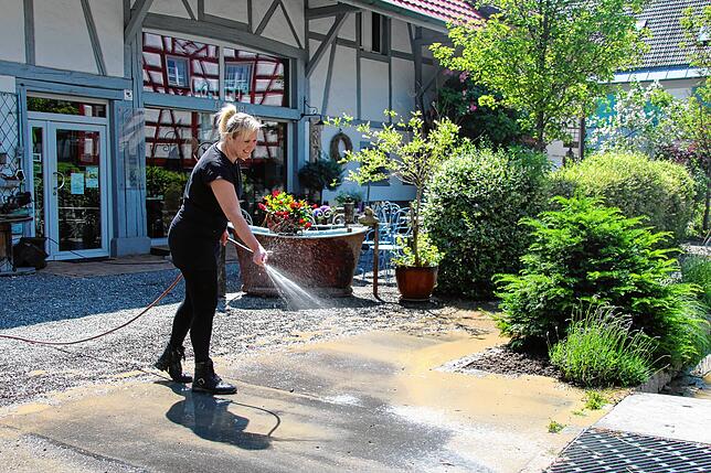 Lisa Keller, Inhaberin des Cafés Stöberei in Bohlingen, spült den letzten Schlamm von den Straßen. Am Dienstag möchte sie wie gewohnt in ...