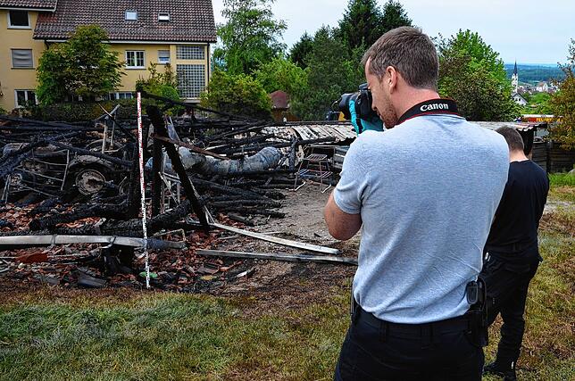 Beamte der Kriminalpolizei nehmen am Sonntag den Brandort im Lilienweg in Augenschein und sichern Spuren. Bei der Kripo hofft man auch ...