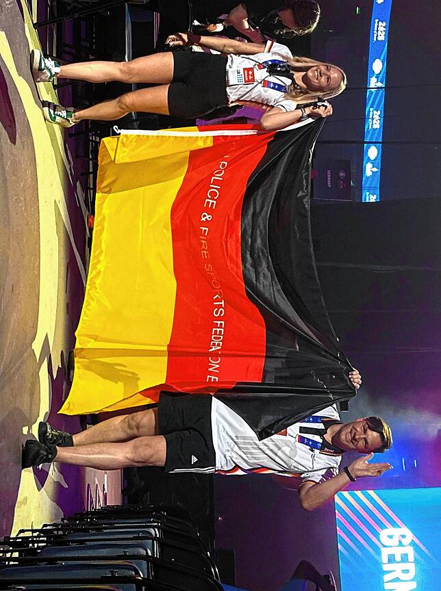 Stefanie Scharder und Daniel Kaiser (von linkS9 tragen die deutsche Fahne bei der Eröffnungsfeier in die Arena.