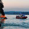 Das Motorboot steht am Samstagabend auf dem Überlinger See vor Unteruhldingen in Vollbrand. Rechts ist ein Feuerlöschboot zu sehen.
