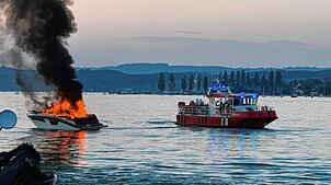 Das Motorboot steht am Samstagabend auf dem Überlinger See vor Unteruhldingen in Vollbrand. Rechts ist ein Feuerlöschboot zu sehen.