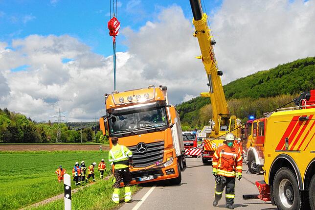 Mit Hilfe eines Krans und einer Seilwinde wird die abgesackte Zugmaschine des Lastwagens wieder auf die B 27 gehoben.