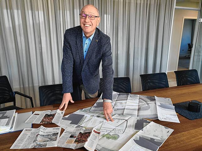 Klaus Werne mit Zeitungsartikeln und den rund zehn Jahre alten Plänen für das Geschäftshaus, das er am Sulzerring errichten will.