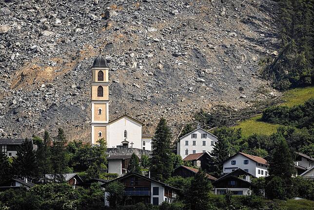 Kurz vor dem Dorf mit der Kirche liegen die Felsmassen. Ein gewaltiger Strom an Fels und Geröll hat nur knapp das Schweizer Bergdorf ...