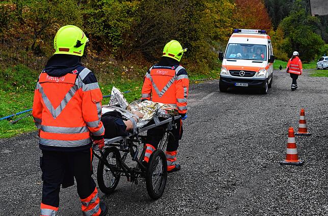Helfer transportieren einen Patienten weiter vom Zelt Eingang/Sichtung in das zugewiesene Zelt.