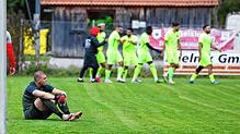 Duro Kacavenda (links, SV Geisingen) sitzt enttäuscht nach dem 2:0 für Singen auf dem Boden. Die Gäste freuen sich über ihren Sieg.