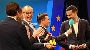 CDU-Kanzlerkandidat Friedrich Merz freut sich beim Wahlkampfbesuch in Singen über eine Maggi-Flasche als Andenken. Mit ihm auf der Bühne ...