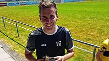 Julian Widmann präsentiert seine Trophäe zum besten Torschützen der Liga, die er von seinen Mannschaftskollegen überreicht bekommen hat.