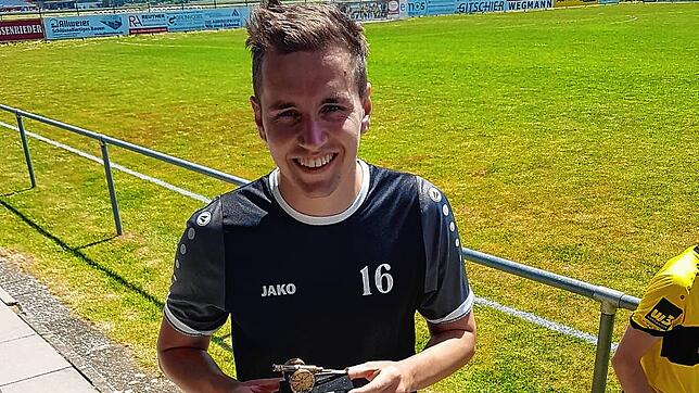 Julian Widmann präsentiert seine Trophäe zum besten Torschützen der Liga, die er von seinen Mannschaftskollegen überreicht bekommen hat.