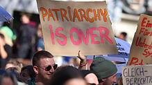 Am Frauentag hält eine Demonstrantin ein Schild mit der Aufschrift „PATRIARCHY IS OVER“ (deutsch: Das Patriarchat ist vorbei) hoch.