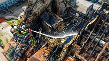 Zwei Feuerwehrleute spritzen am Sonntagmittag Wasser in die Brandruine zwischen Gerberstraße und Goldgrubengasse.