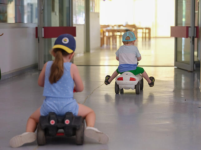 Kinder flitzen im Kindergarten mit einem Bobbycar über den Gang. Die Betreuung in den Häfler Kitas wird ab September deutlich teurer.