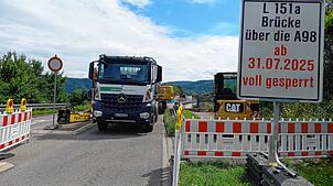 Ein LKW wird vor der über die A98 führende Brücke L151a von einem Bagger mit Straßenbelag beladen. Seit Donnerstag ist die Brücke beim ...