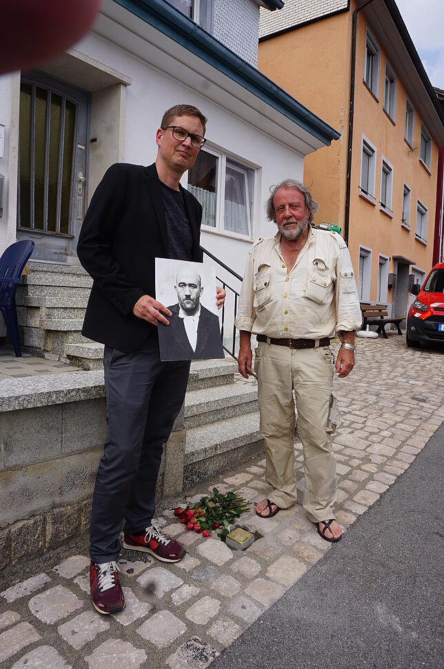 Der Kölner Künstler Gunter Demning (rechts) setzt den Gedenkstein ein, hier zusammen mit dem Initiator Jörg Waßmer.