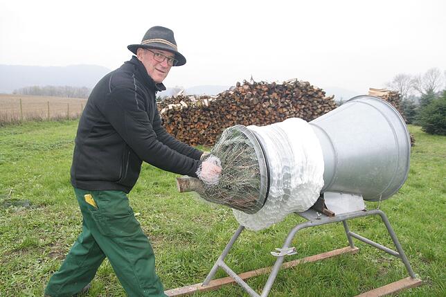 Bernd Grießer beim Verpacken eines Weihnachtsbaums in ein Netz.